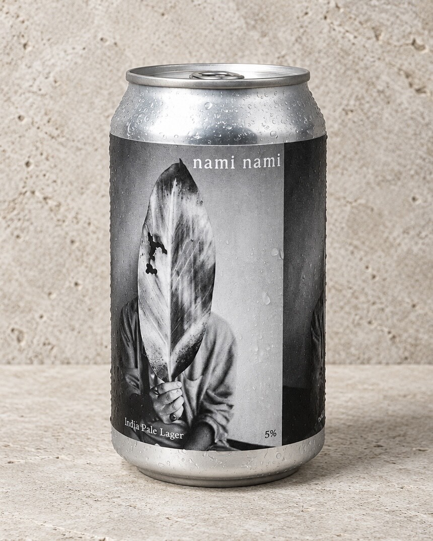 A chilled nami nami can, beaded with condensation, its label a black-and-white photograph of a figure holding a leaf.